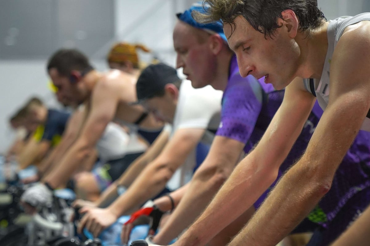 A row of men on spin bikes