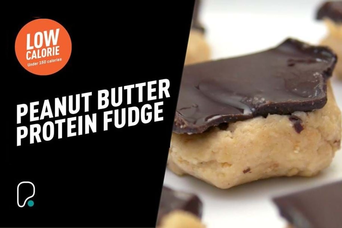 Peanut butter protein fudge squares topped with dark chocolate on a white plate