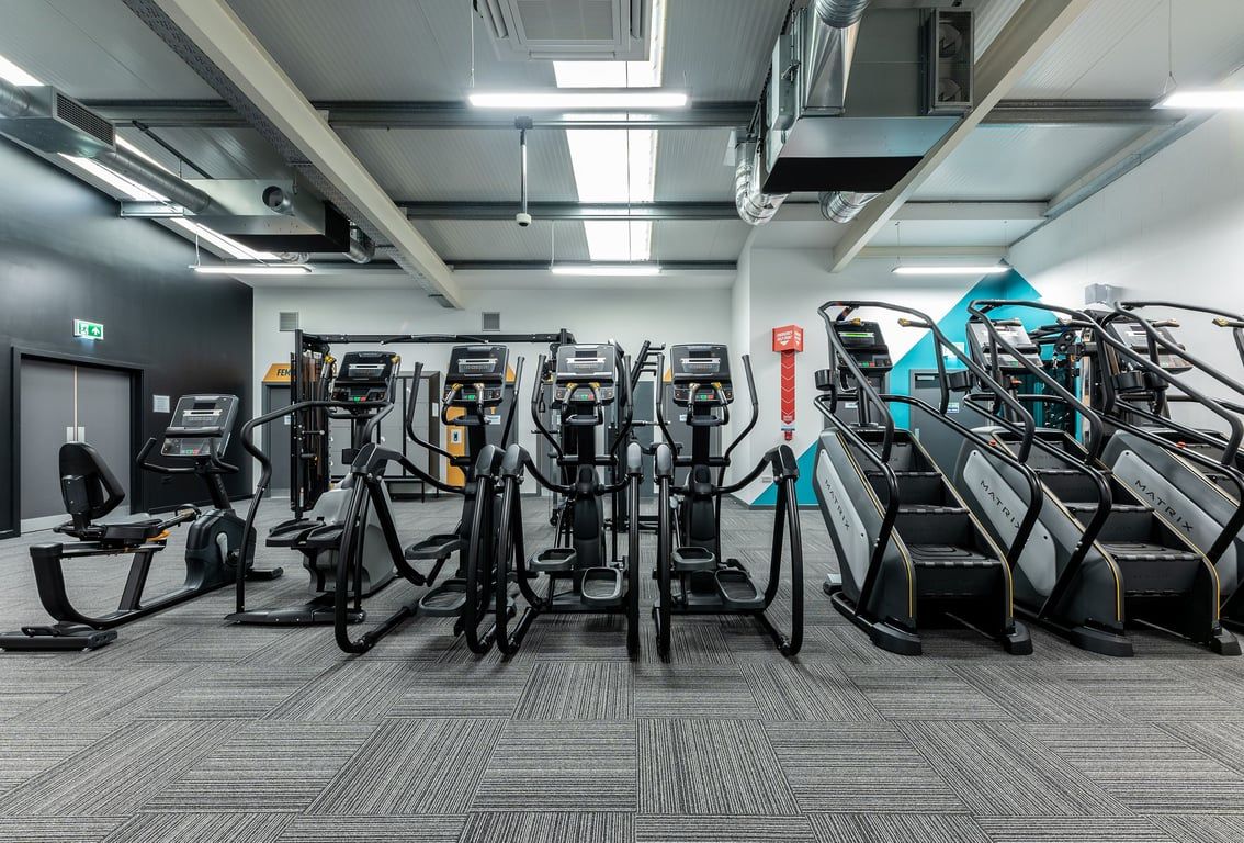 PureGym Maidenhead: Rows of elliptical trainers, treadmills, and exercise bikes in a modern fitness centre.