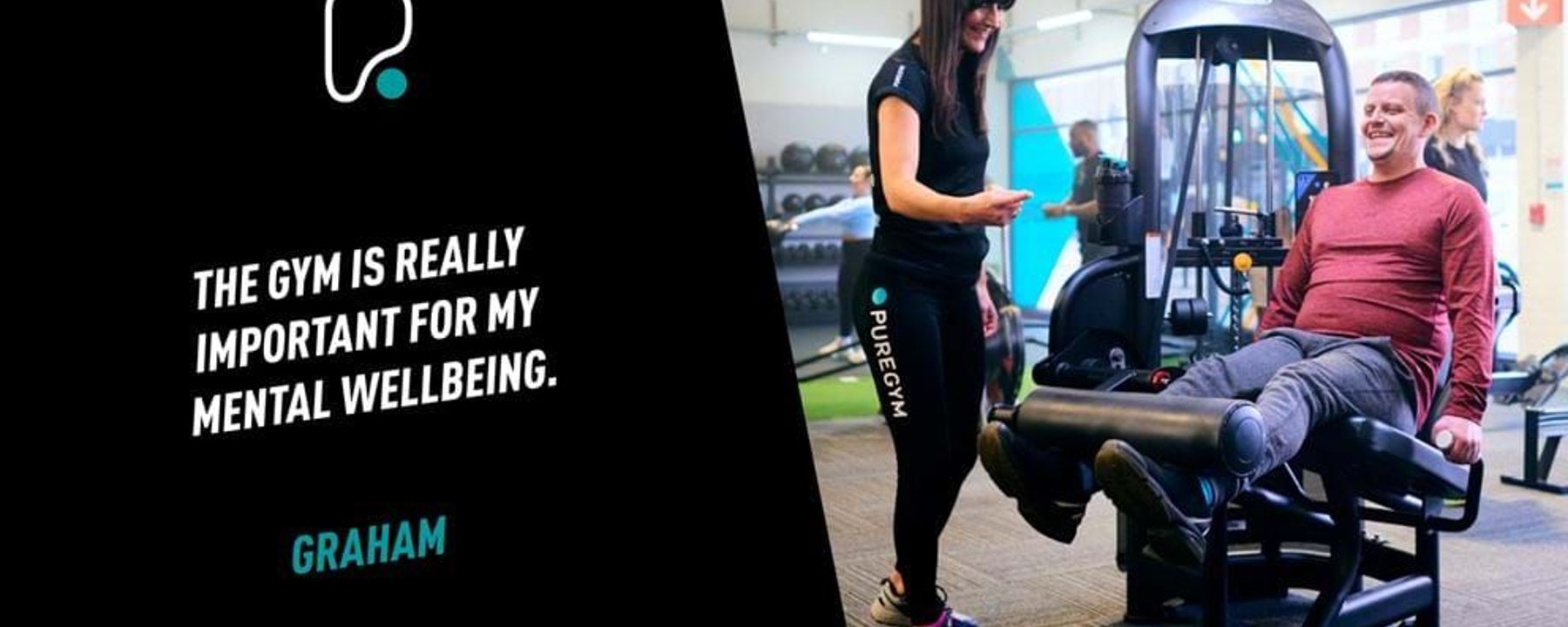 Man exercising legs on machine with female trainer smiling beside him in gym