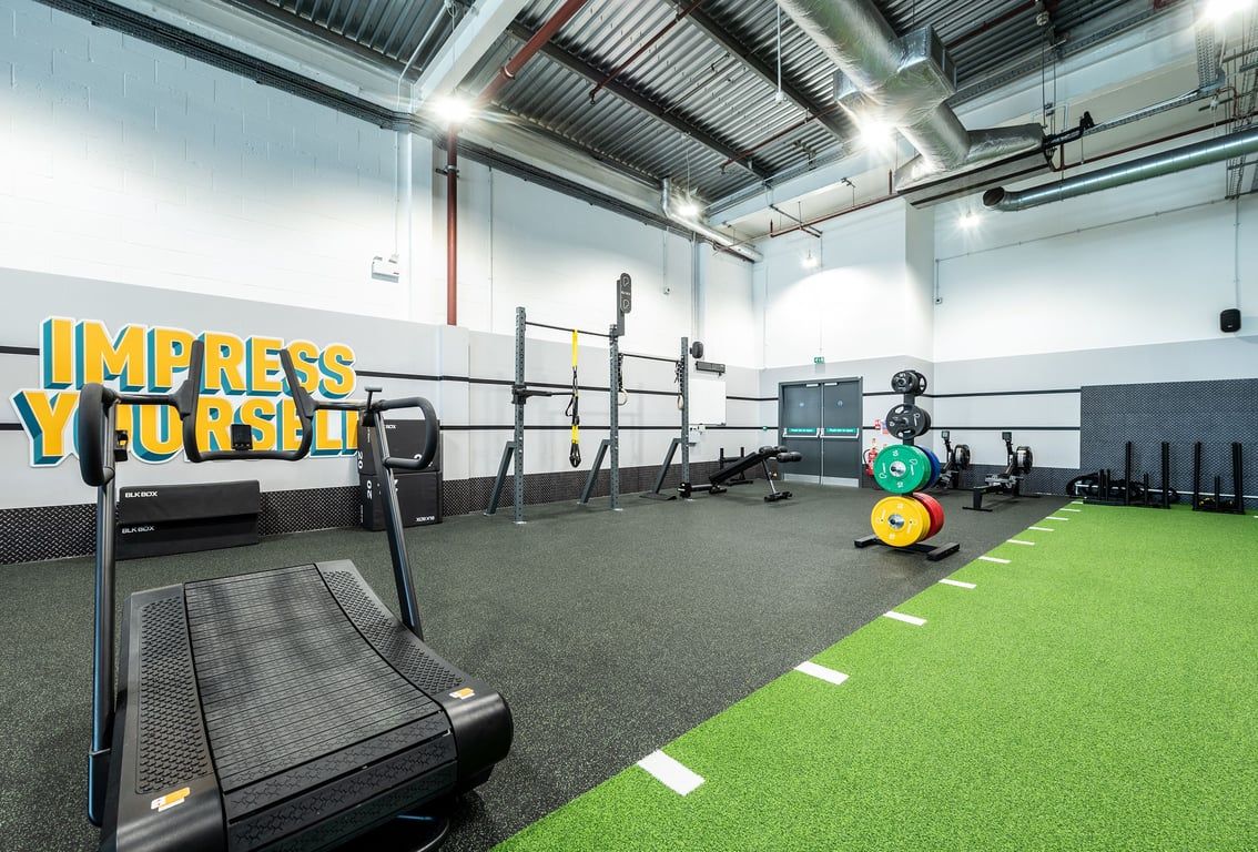 PureGym Newport Wales: Treadmills, squat racks, free weights, and turf area for functional training.
