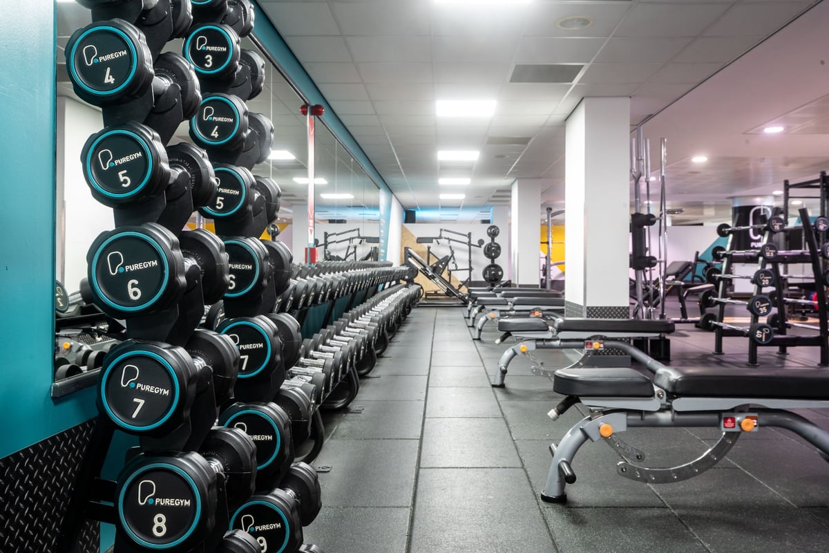 PureGym Edinburgh Exchange Crescent: Rows of dumbbell racks, weightlifting platforms, rubberized flooring in a gym setting.