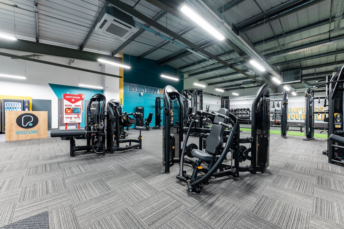 PureGym Alloa: Rows of strength training machines, free weights, benches and mirror-walled interior of a gym studio.