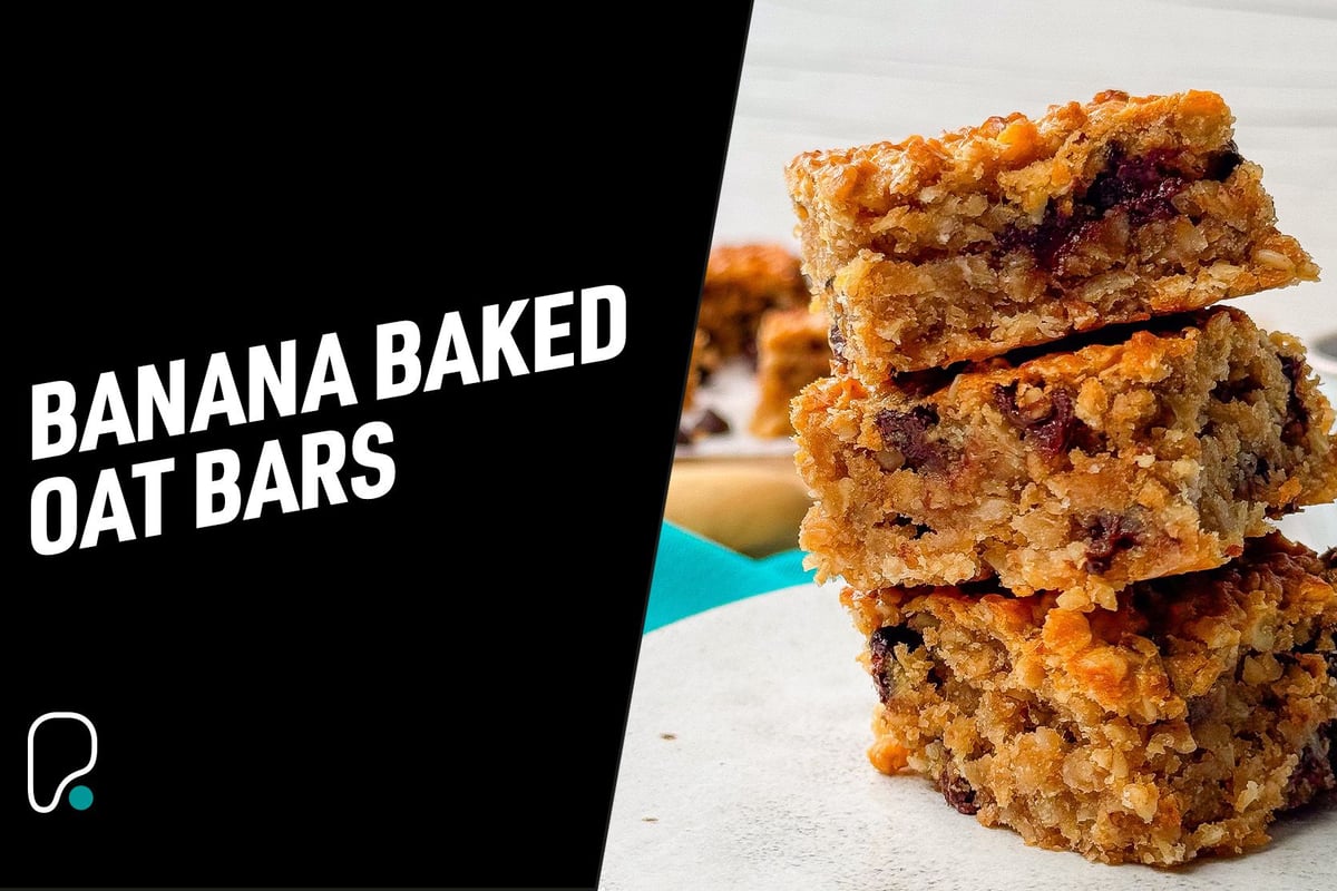Stack of three banana baked oat bars with visible berries on a white plate