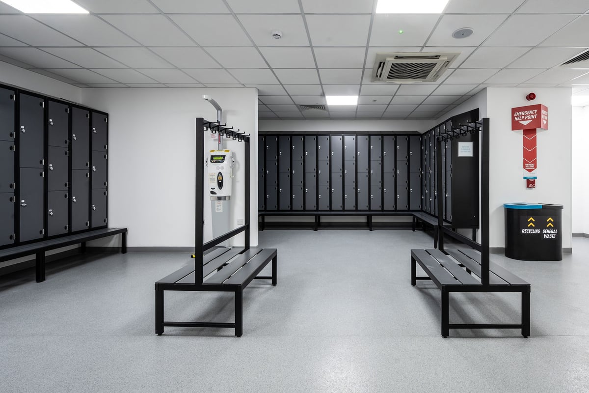 PureGym Newtownabbey: Locker room benches, open lockers, and hygiene station.