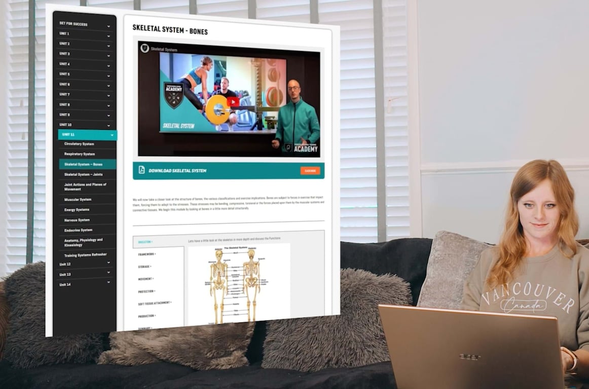 woman sitting on sofa using laptop with skeletal system educational content on screen