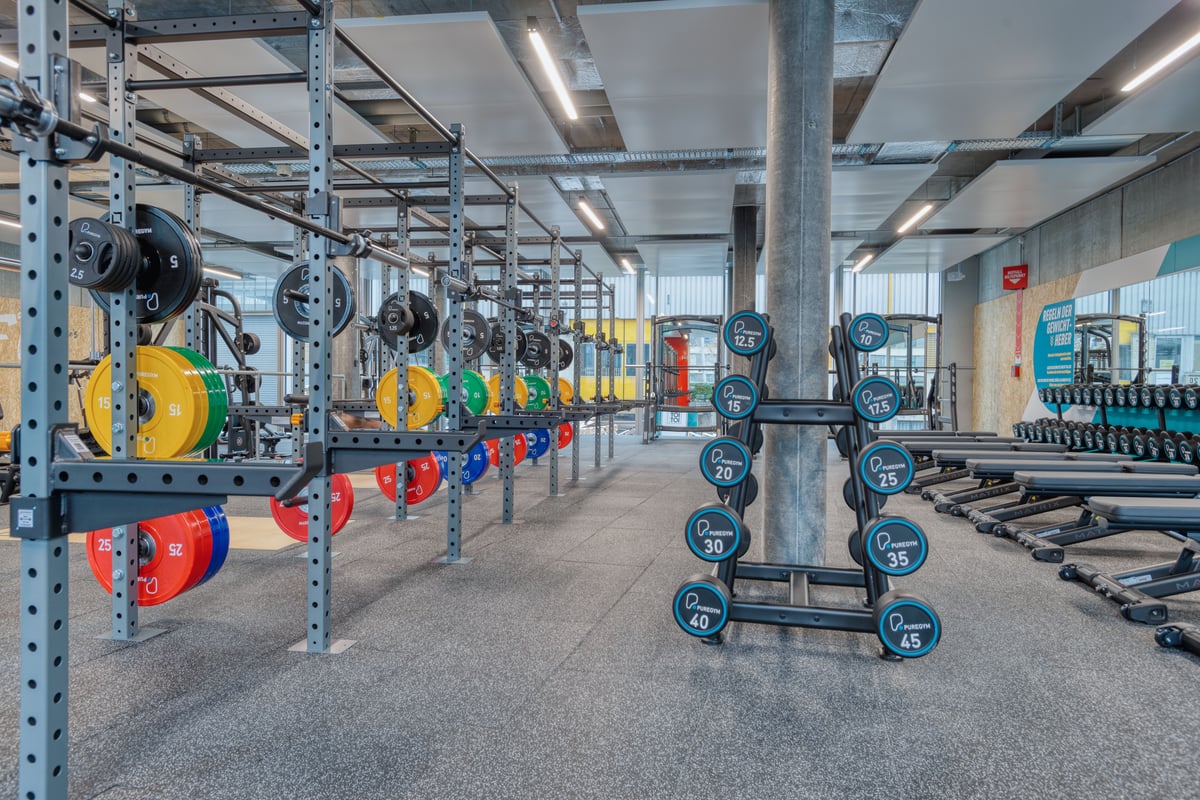PureGym Zürich Oerlikon: Robuste Gym‑Rig‑Anlage mit Langhanteln, Bumper‑Plates und Trainingsplattformen.