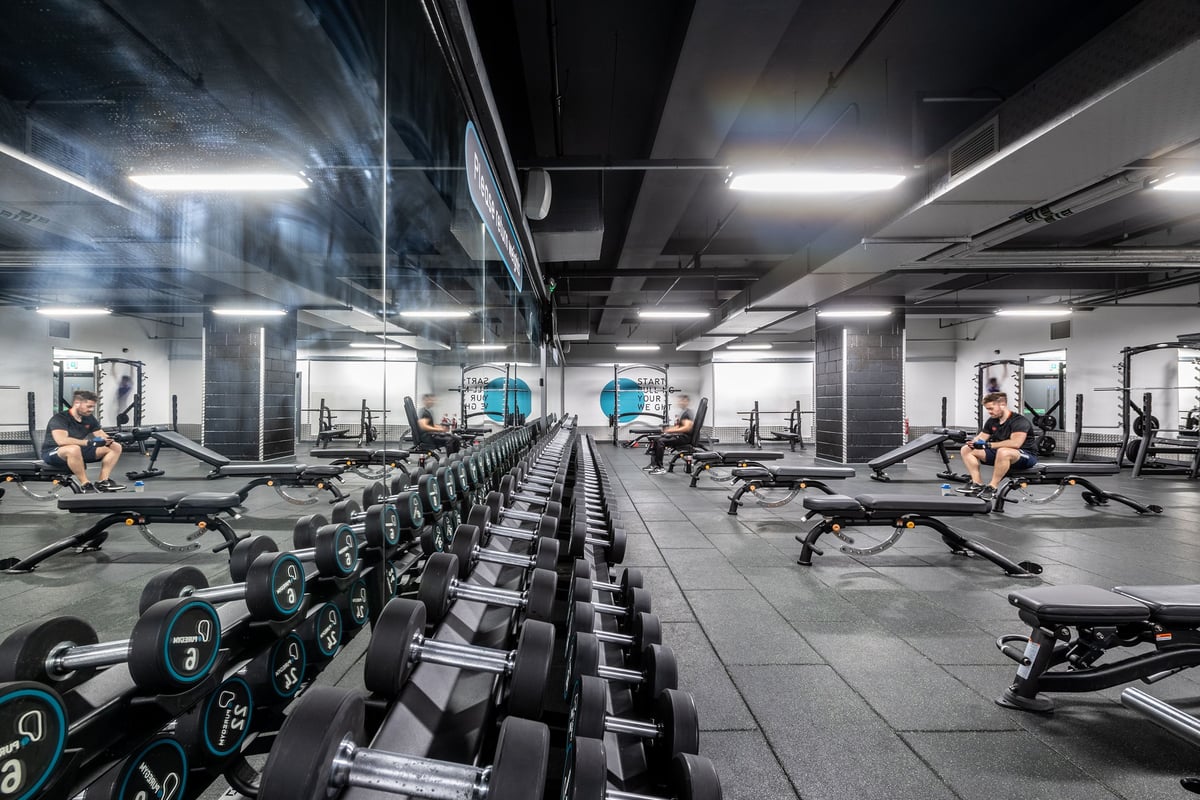 PureGym Liverpool Central: Rows of rowing machines, cable pulley stations, and free weights in an industrial-style gym.