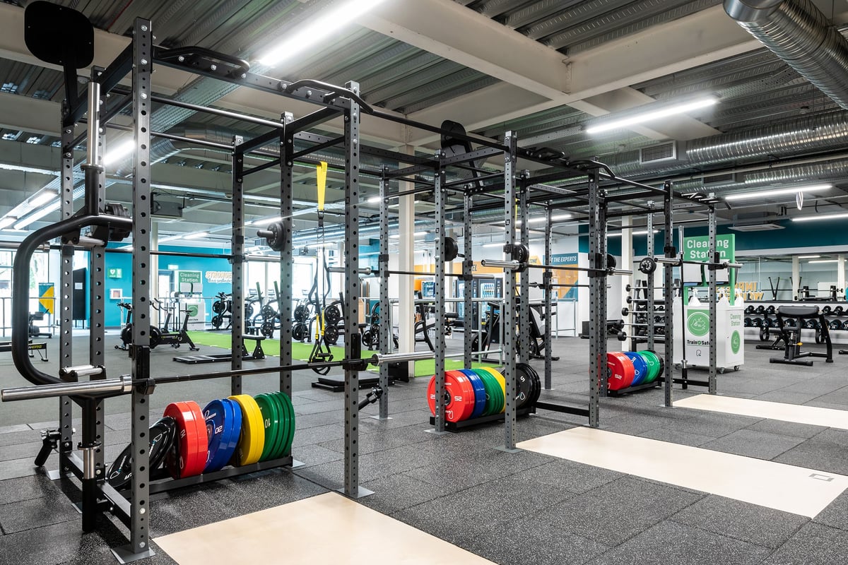 PureGym Cheshunt Brookfield Shopping Park: Rig with weight plates, bars, squat racks, mirrored walls, and rubberized floors.