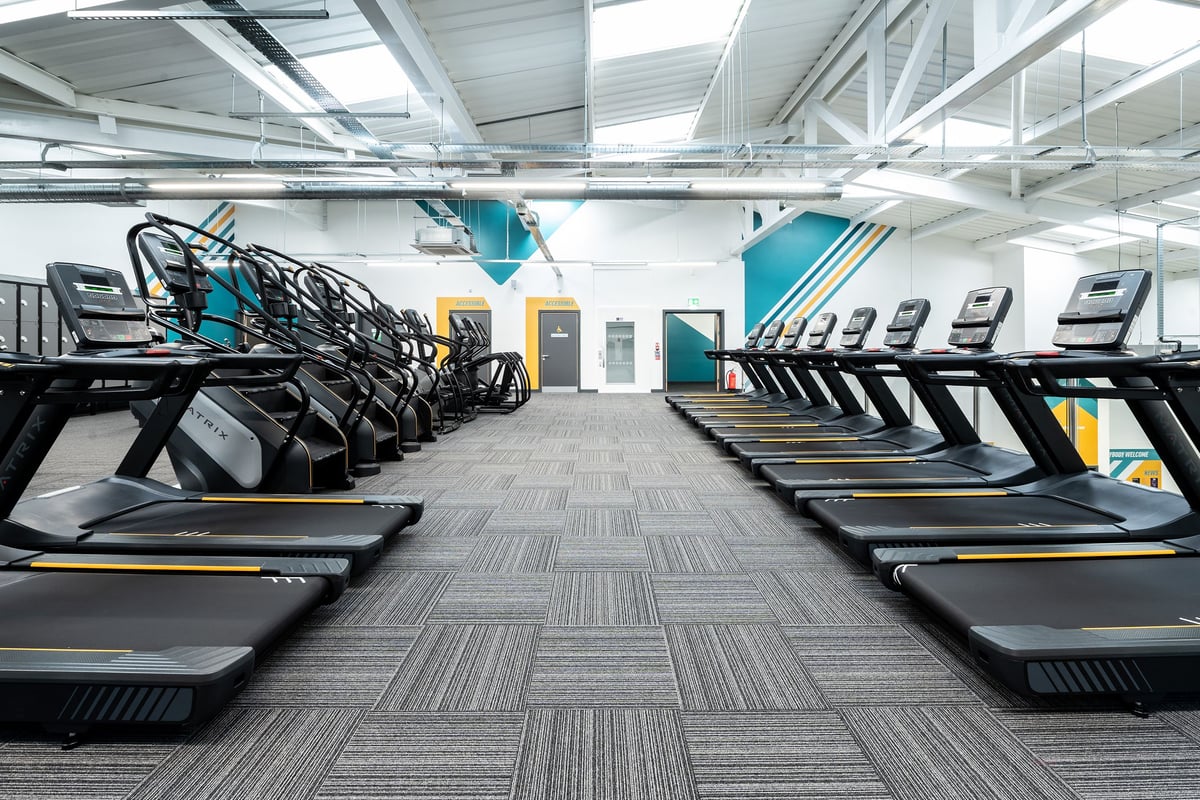 PureGym Yeovil Houndstone Retail Park: Rows of treadmills with teal accents in a brightly-lit fitness facility.