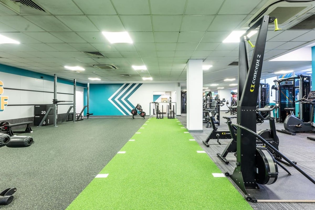 PureGym Purley: Resistance machines, turf area, free weights, mirrors along walls, rubberized flooring.