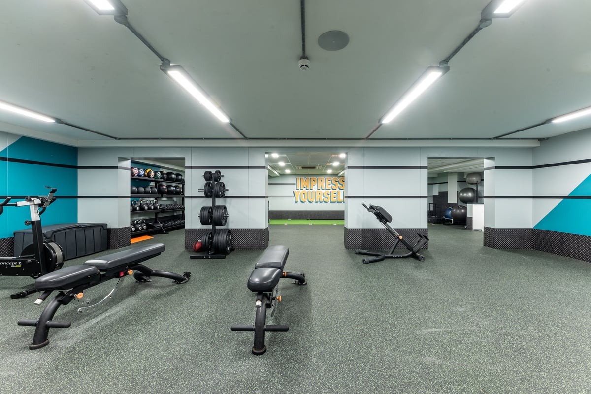 PureGym London Muswell Hill: Gym with resistance machines, free weights, mirrors along walls, and rubberized flooring.