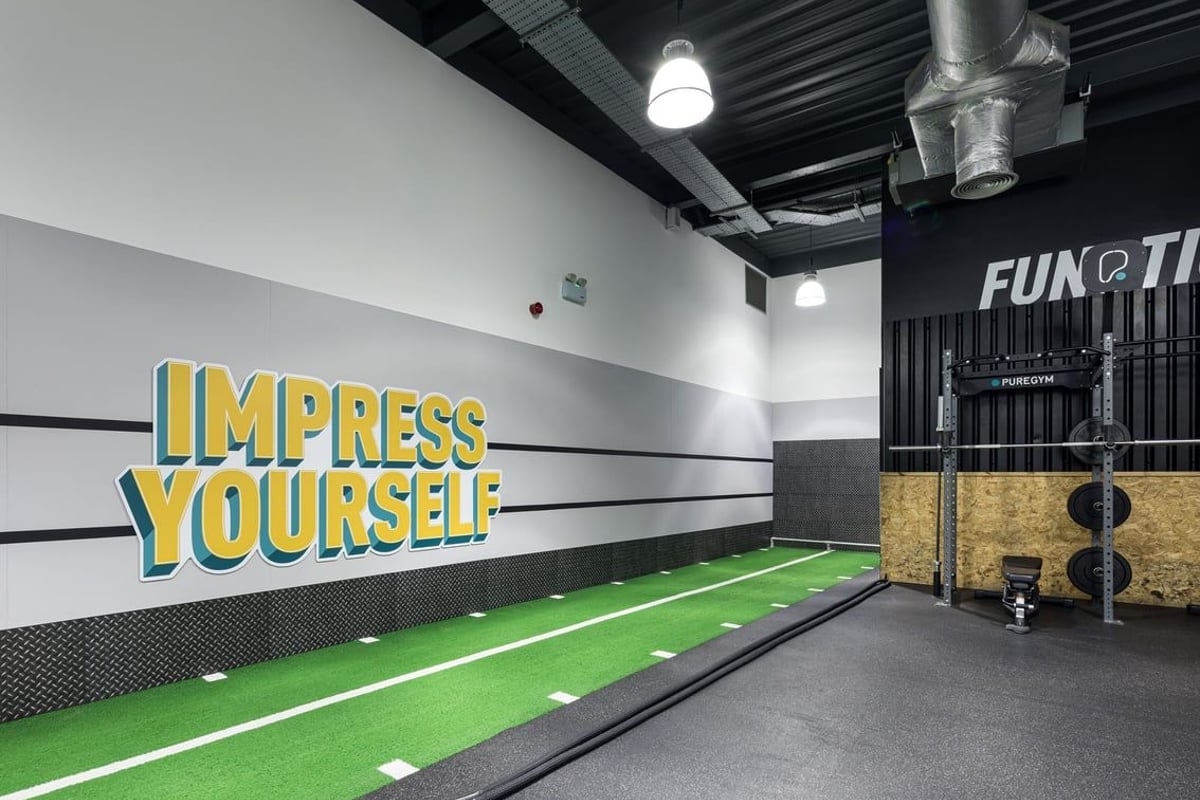 PureGym Dudley Tipton: Bowling alley, green turf track, weight racks, motivational wall signage.