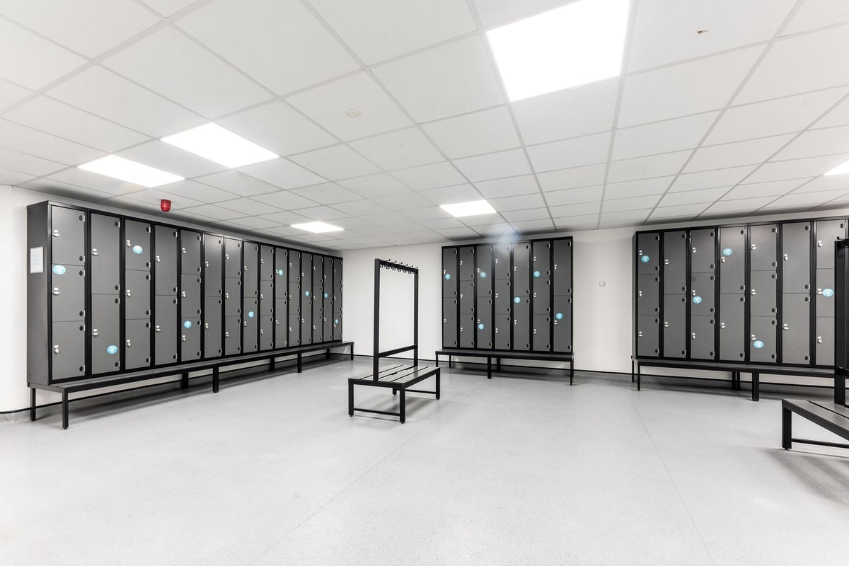 PureGym Brierley Hill: Lockers, benches, and mirrored walls in a communal changing room.