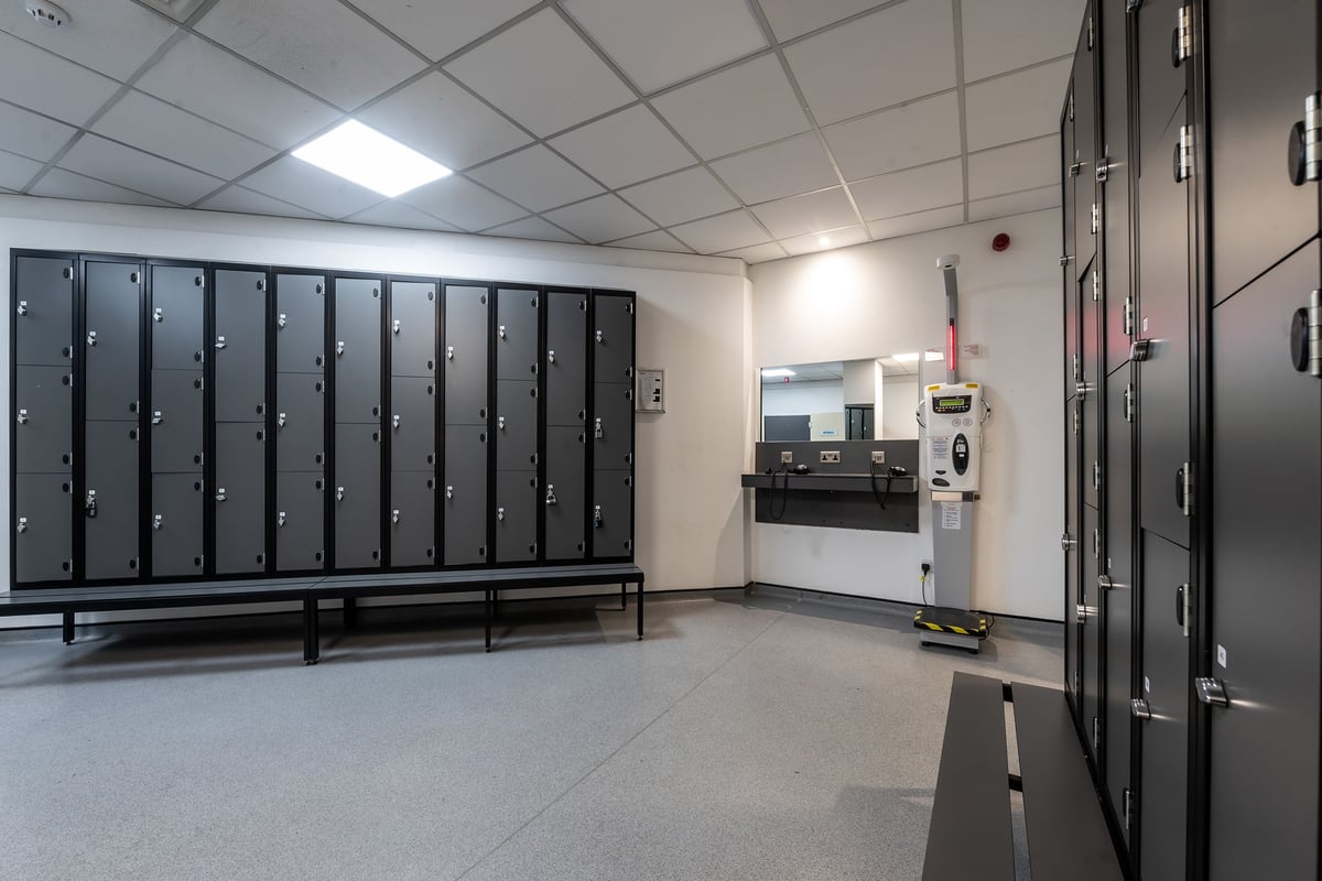 PureGym Rochdale: Rows of lockers, benches, and what appears to be changing room facilities.