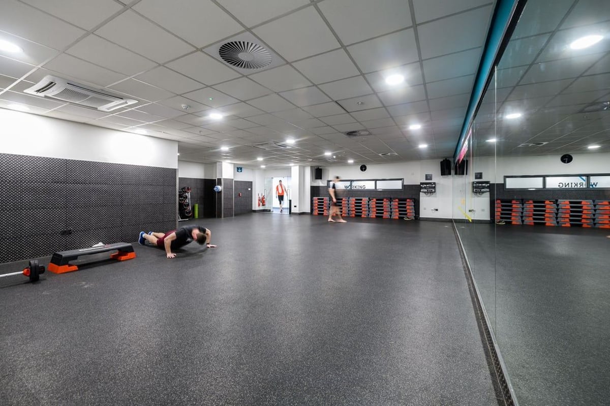 PureGym London Moorgate: Rubberized floor, weight racks, mirrored wall, weightlifting platforms, exercise equipment.