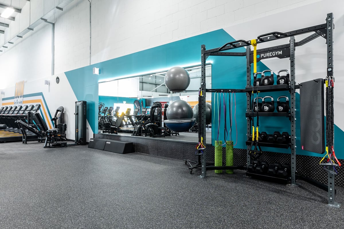 PureGym Great Yarmouth: Functional training rigs, weighted balls, resistance bands, rubberized flooring in fitness studio.