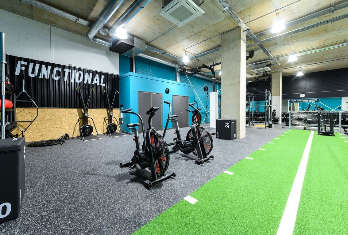 PureGym London Kidbrooke Village: Spin bikes, rowers, weightlifting area with turf, functional training rig.