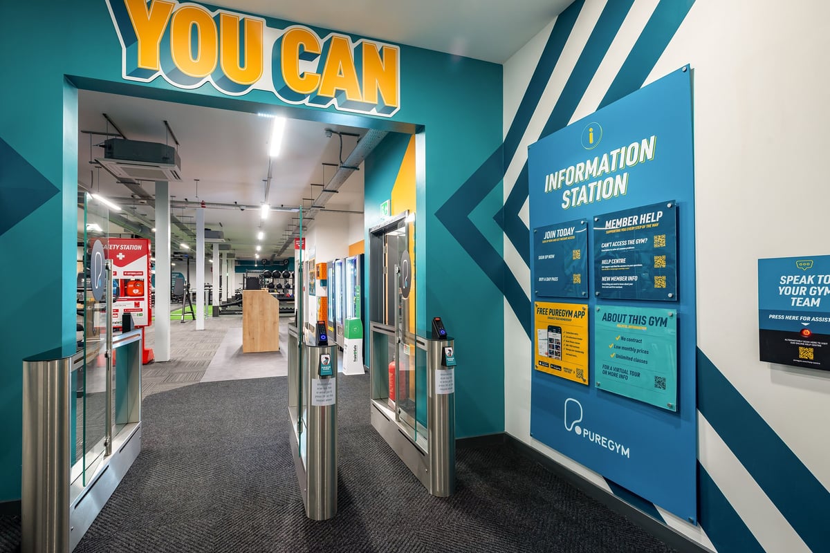 PureGym Stratford-upon-avon: Hallway leading to gym area with "You Can" signage and information station.
