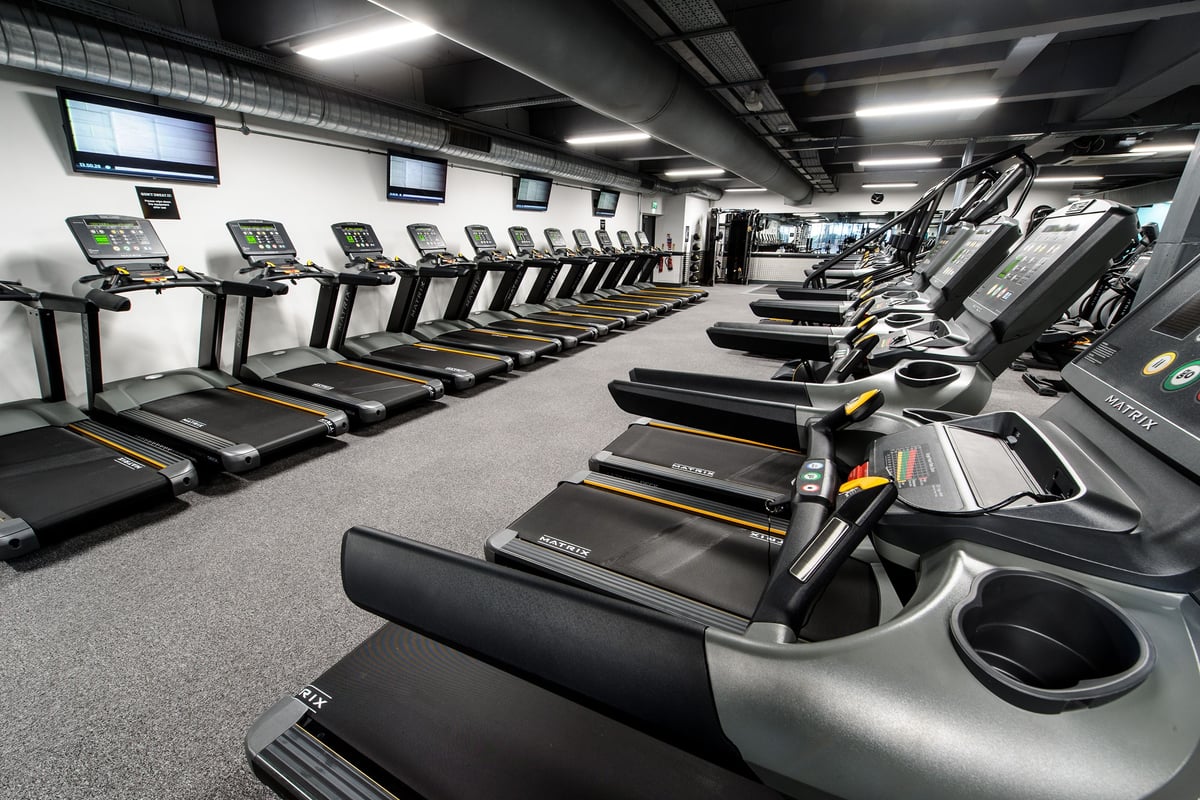 PureGym London Wembley: Rows of treadmills and other cardio machines in a brightly lit fitness studio.