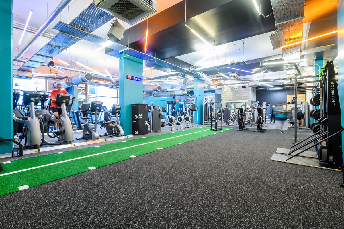 PureGym London Borough: Strength equipment, turf area, weights, cardio machines in a vibrant modern gym interior.