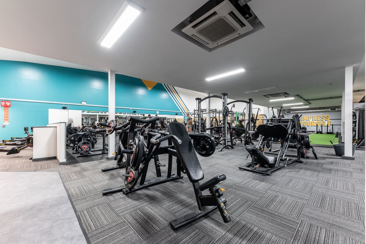 PureGym West Thurrock: Gym studio with resistance machines, free weights, mirrors along walls, and rubberized flooring.