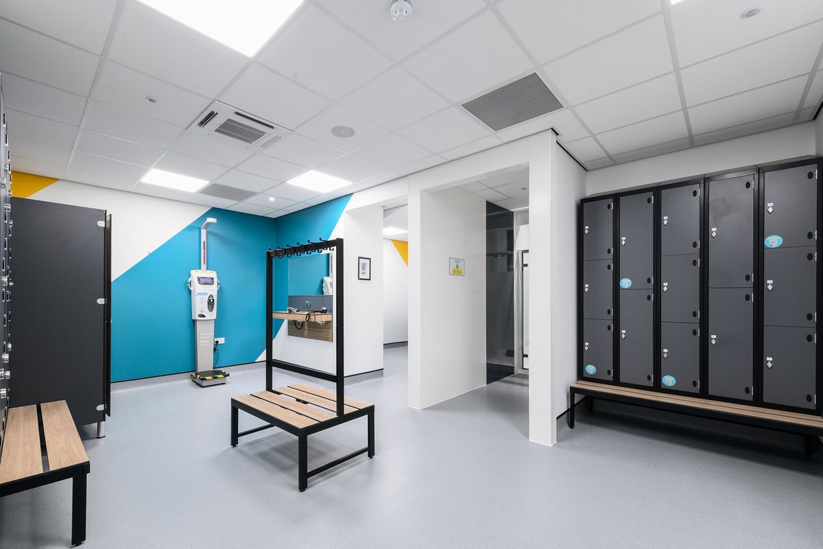 PureGym South Ruislip: Lockers, benches, hand sanitizer dispenser in a changing room setting.