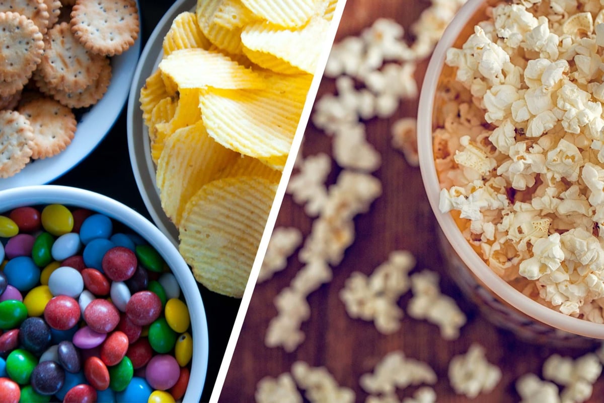 Bowls of popcorn, potato chips, colourful candy-coated chocolates, and crackers
