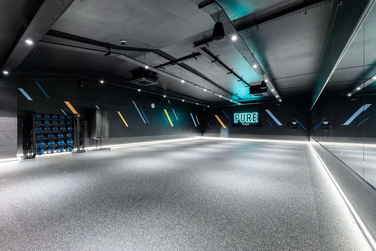 PureGym Redditch Ringway: Futuristic studio interior with rubberized floor and neon lighting