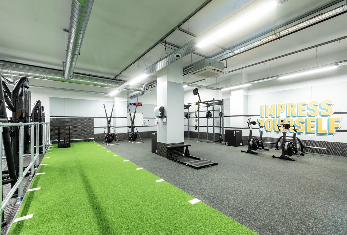PureGym London Crouch End: Resistance machines, green turf area, weight racks, rubberized flooring.