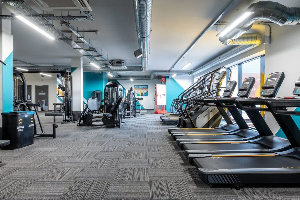 PureGym London Swanley: Rows of treadmills, resistance machines, weight benches in an industrial-style gym interior.