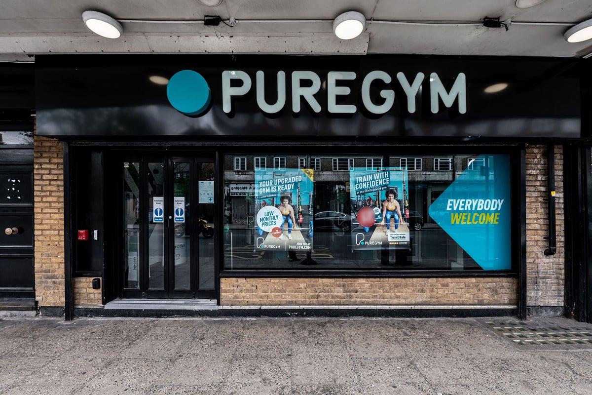 PureGym London Sydenham: Gym exterior with logos, posters depicting fitness activities, and an "Everybody Welcome" sign.
