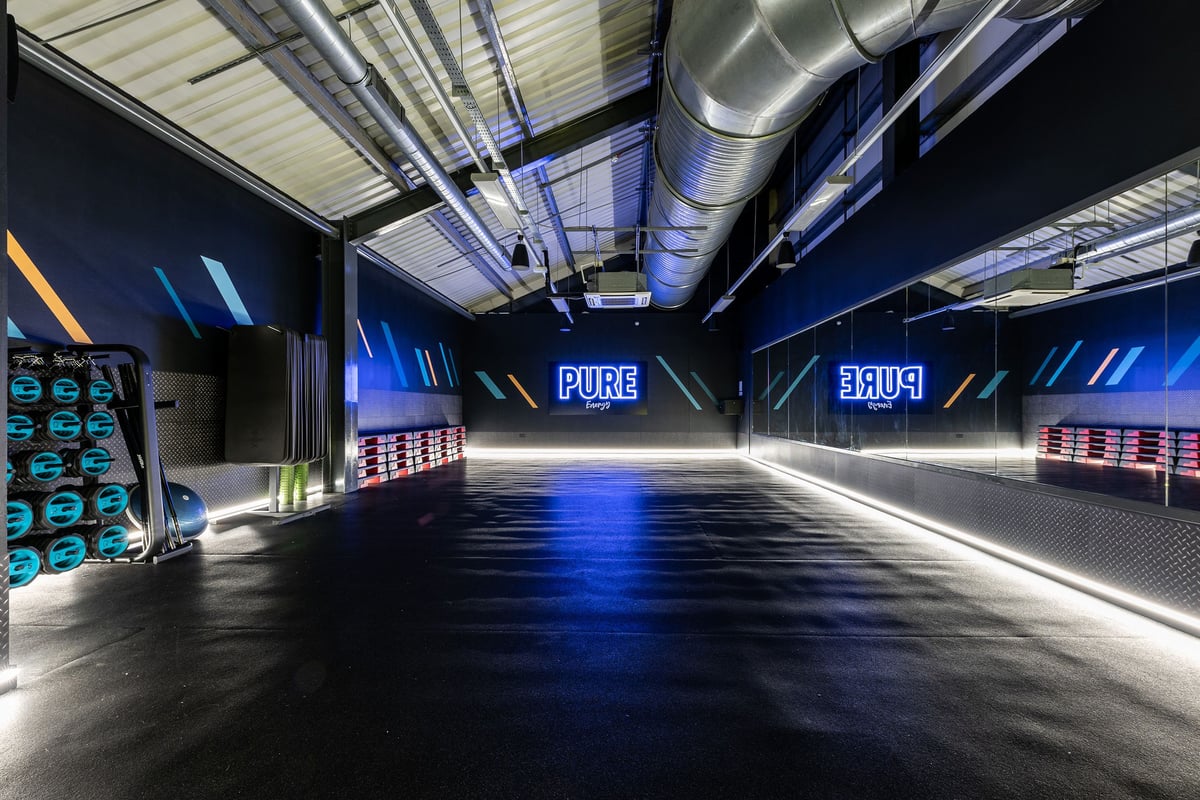 PureGym Chatham: Blue-lit studio with stepping plates, free weights, and floor mats. Pure Energy features on the far wall.