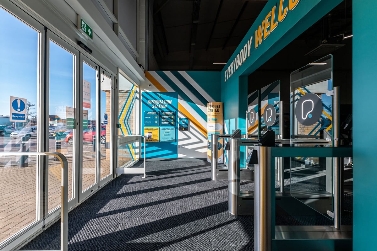 PureGym Great Yarmouth: Automated kiosks, teal branding, glass entry with turnstiles.