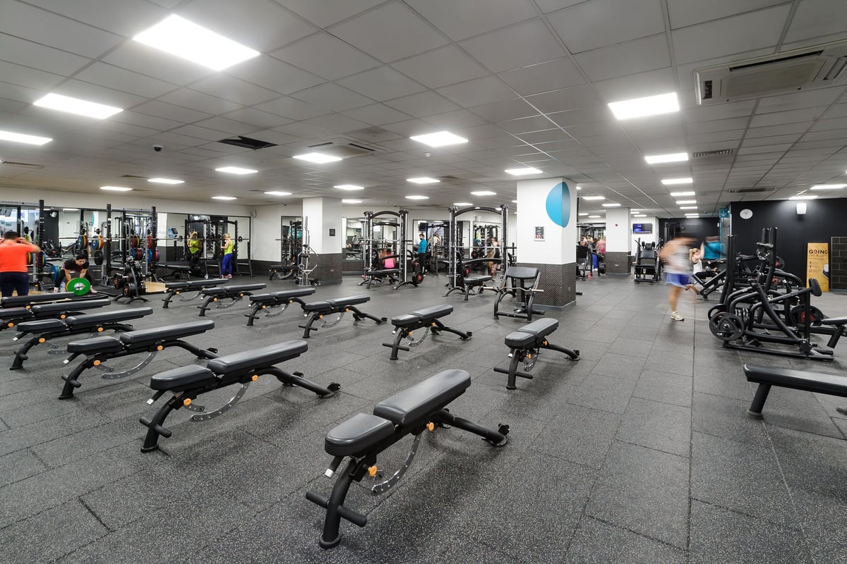 PureGym Glasgow Bath Street: Benches, weight machines, free weights, and rubberized flooring in a well-lit gym space.