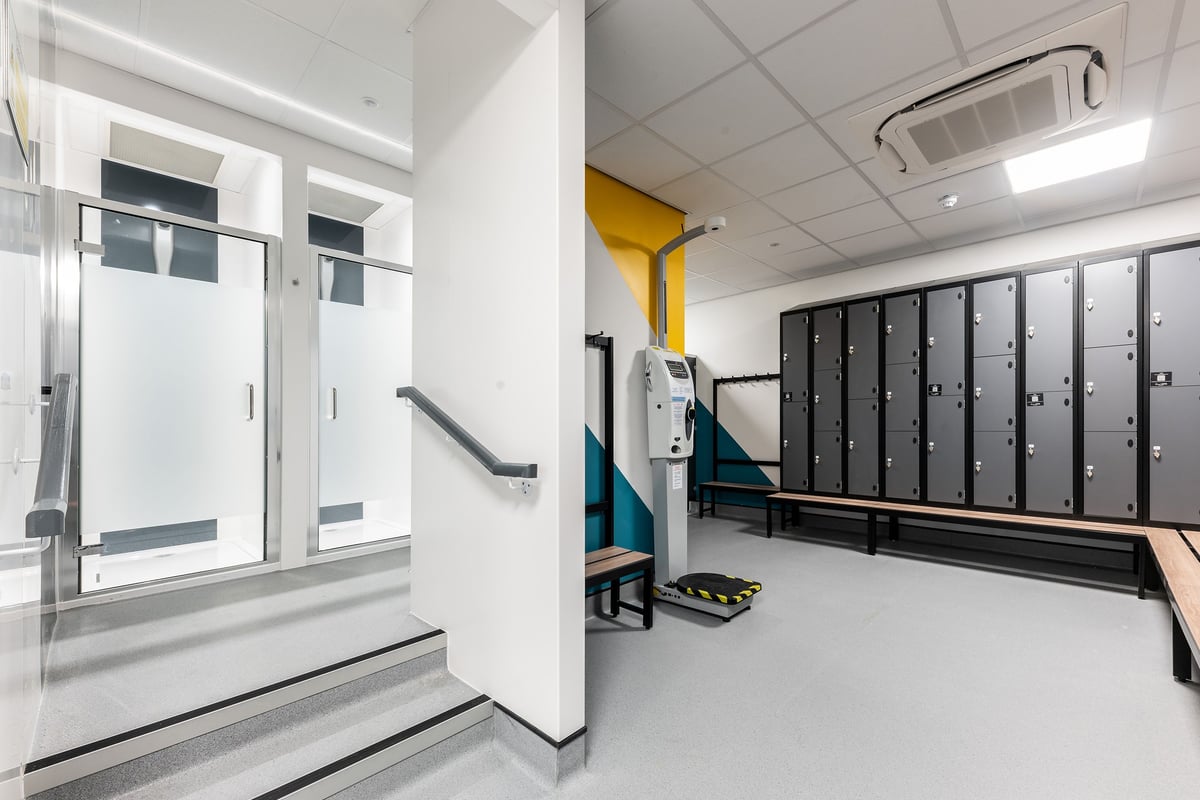 PureGym Ballymena: Metal lockers, benches, swinging door entryways - typical changing room amenities.