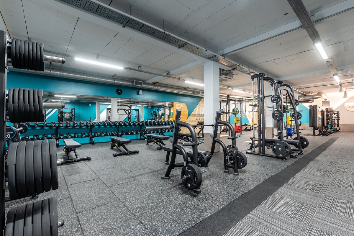 PureGym London Hornchurch: Weightlifting area with dumbbell racks, squat racks, weight plates, and exercise machines.