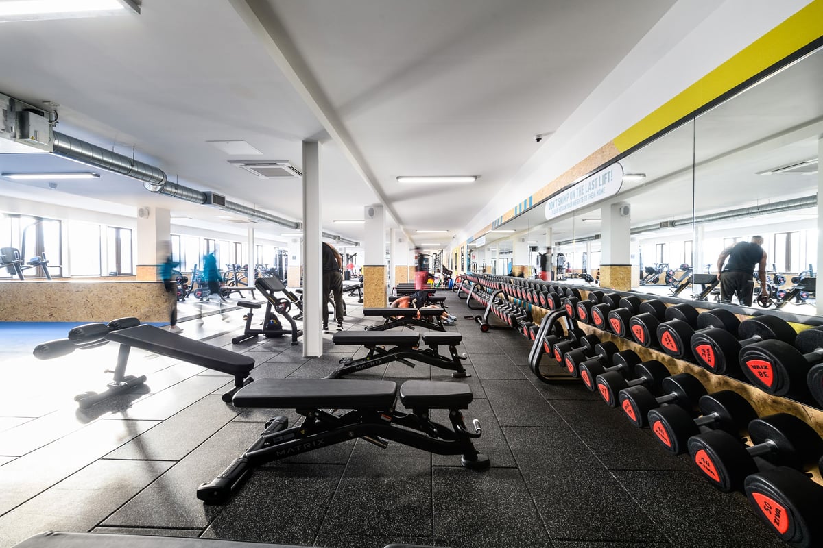 PureGym Telford: Rows of treadmills, weight benches, dumbbells and rubberised flooring in a gymspace.