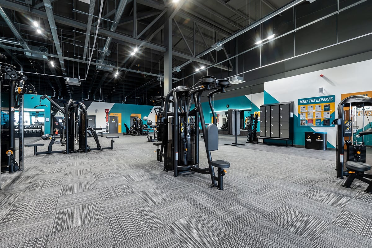 PureGym Walsall Crown Wharf: Weight machines, resistance equipment, teal branding, and rubberized flooring in a gym space.