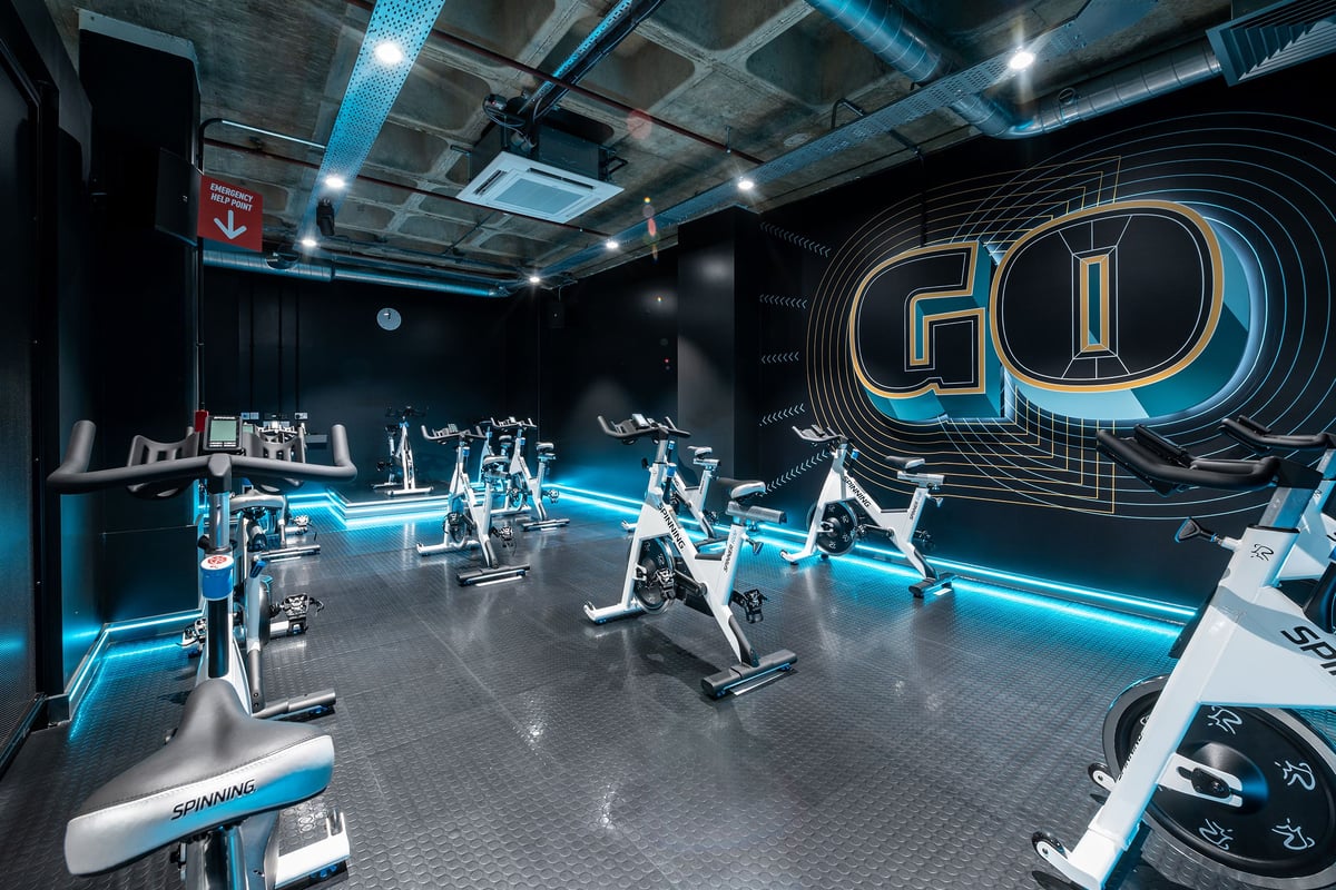 PureGym Maidstone The Mall: Futuristic gym with treadmills, weight racks, and neon blue lighting accents.