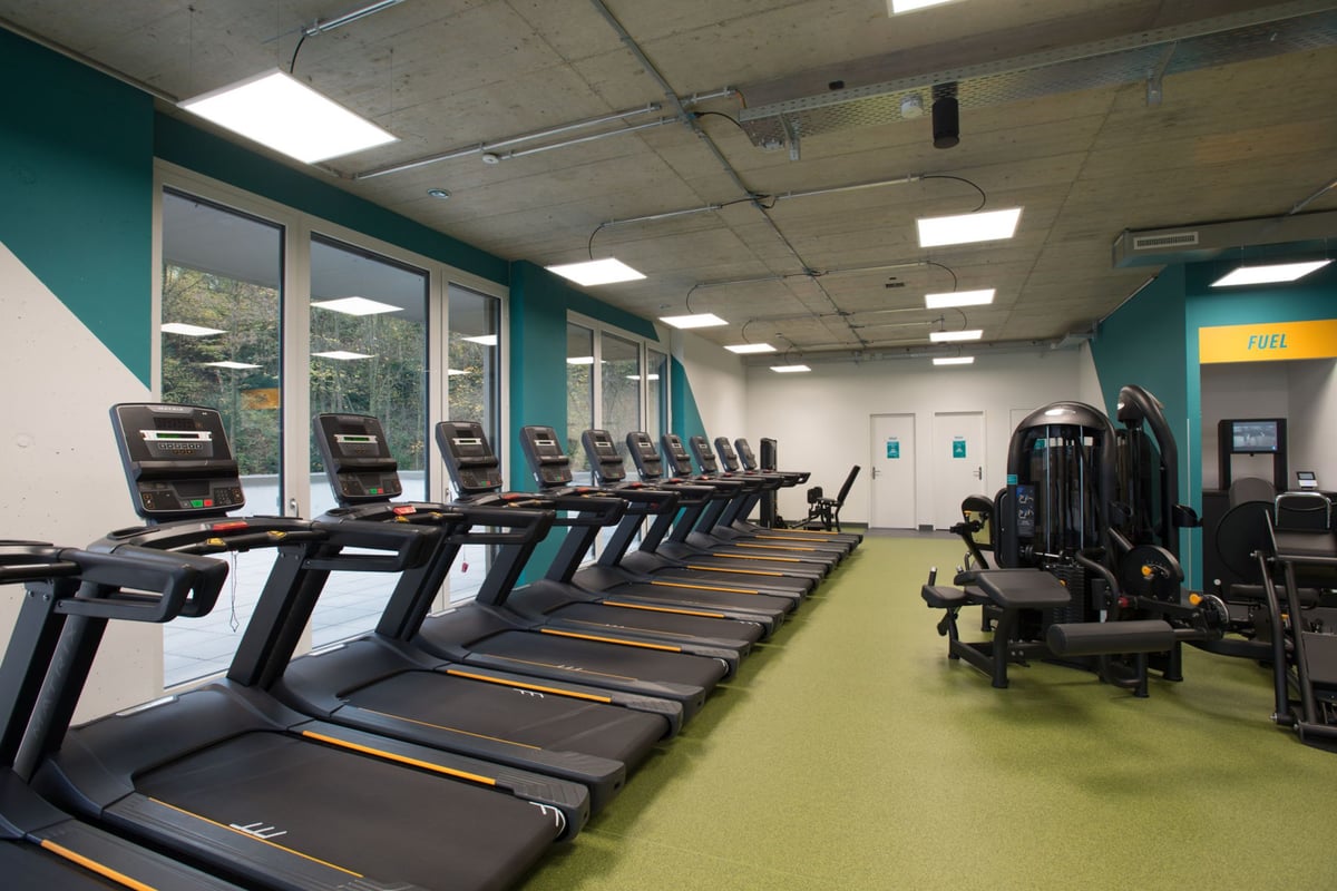 PureGym Adliswil: Des rangées de tapis roulants, de vélos d'exercice et d'appareils de musculation.