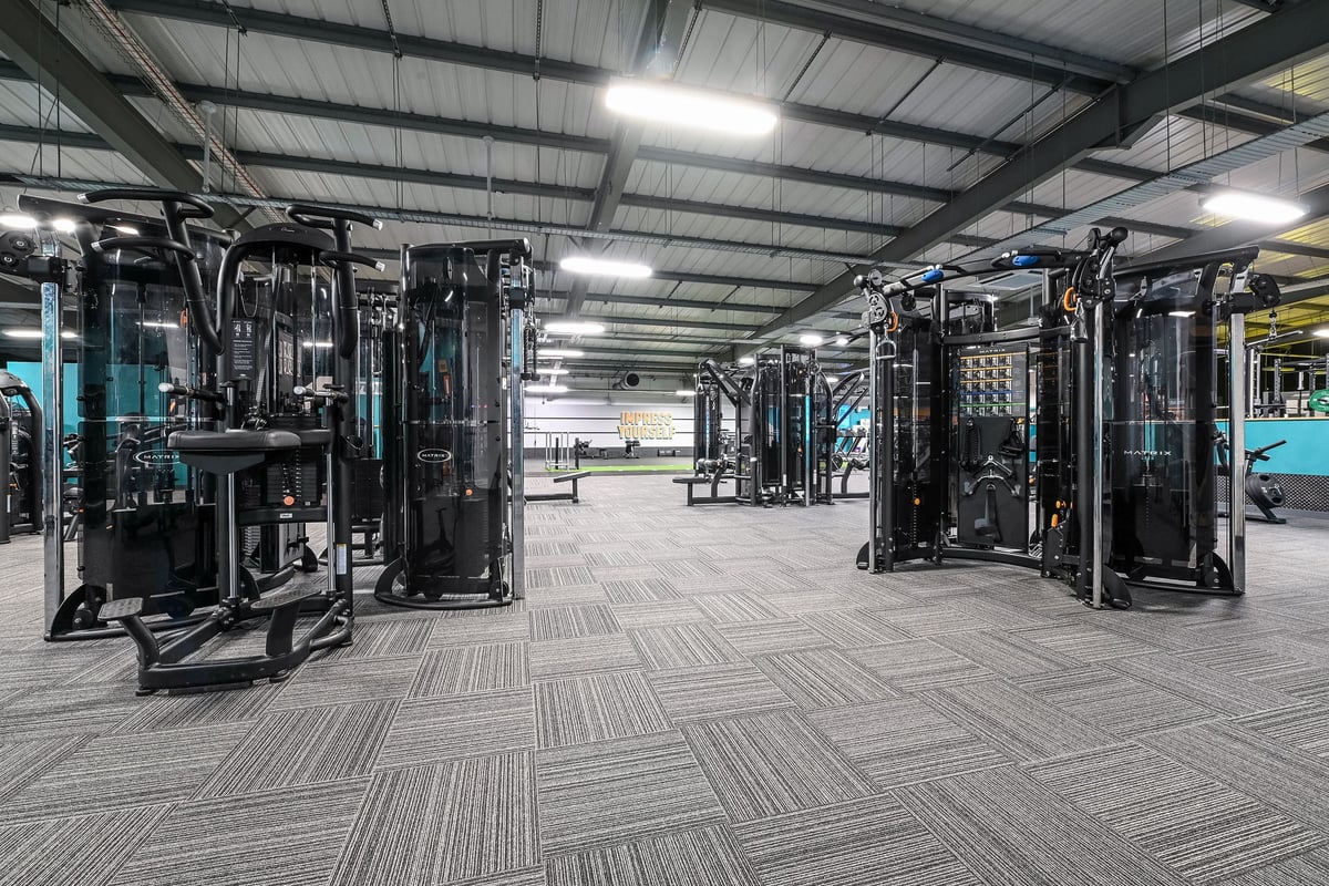 PureGym Canterbury Sturry Road: Rows of resistance machines, cable crossovers, and rubberized flooring in a gym setting.