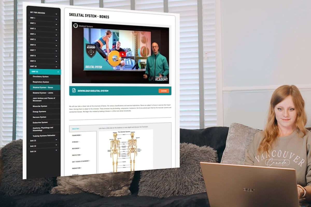 woman sitting on sofa using laptop with skeletal system educational content on screen