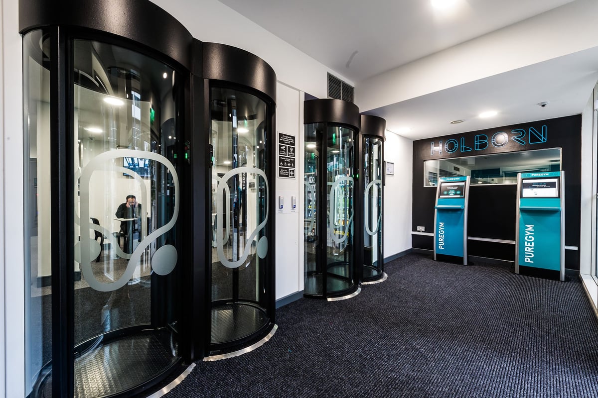 PureGym London Holborn: Entrance pods against dark walls, with a reception area visible.