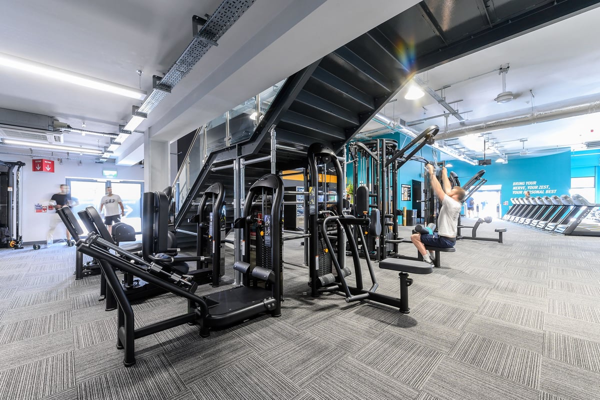 PureGym Bath Spring Wharf: Rows of weighted strength machines, free weights, benches and rubberised flooring in a gym studio.