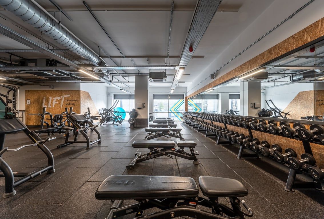 PureGym Stevenage: Rows of treadmills, exercise bikes, weight benches, and free weights in a industrial-style gym.