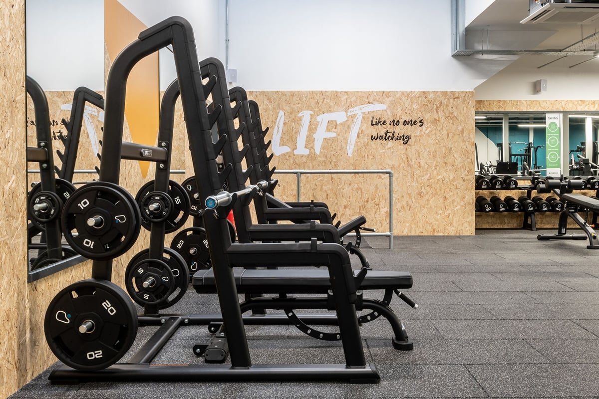 PureGym Inverness Inshes Retail Park: Rows of weighted sleds and resistance machines on rubberized flooring in a gym space.