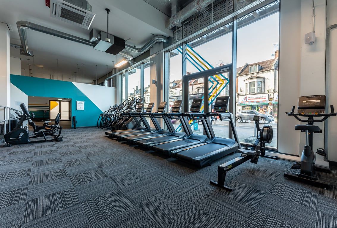 PureGym London Seven Sisters: Rows of treadmills, exercise bikes inside a modern gym with large windows.