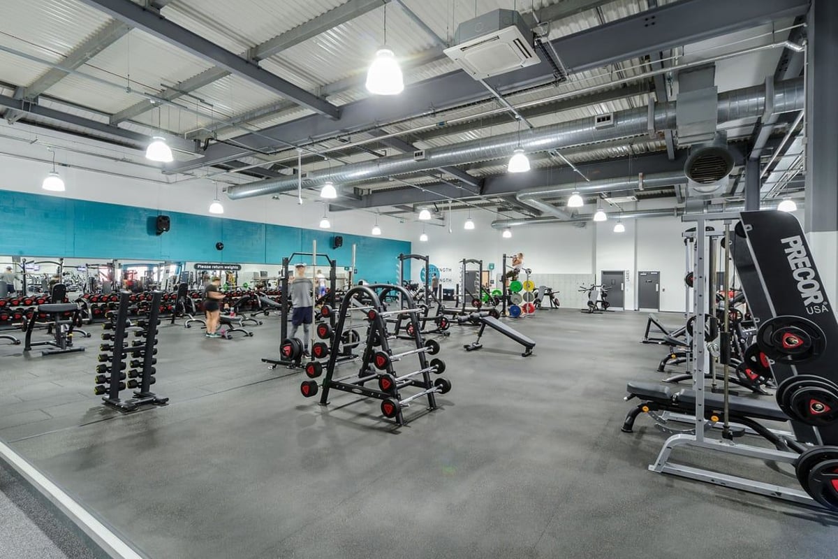 PureGym Worcester: Weight racks, dumbbell stands, exercise machines, and mirrored walls in a large gym space.