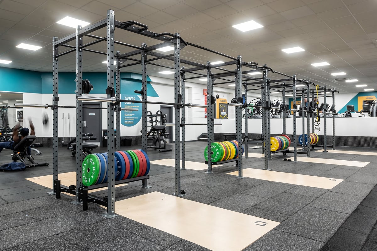 PureGym Birmingham Beaufort Park: Weightlifting rigs, weight plates and rubberised flooring in modern gym studio.